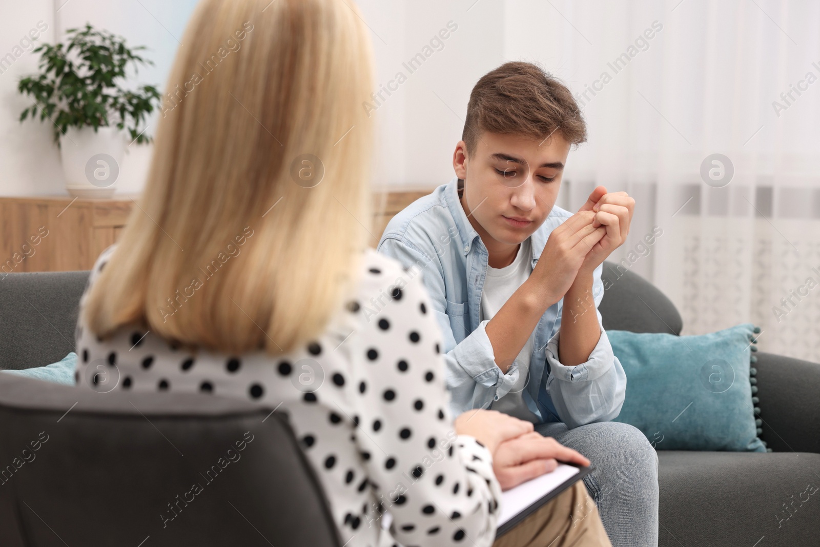 Photo of Psychologist working with teenage boy in office