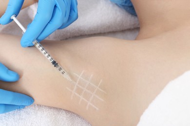 Cosmetologist injecting young woman's armpit, closeup. Treatment of hyperhidrosis