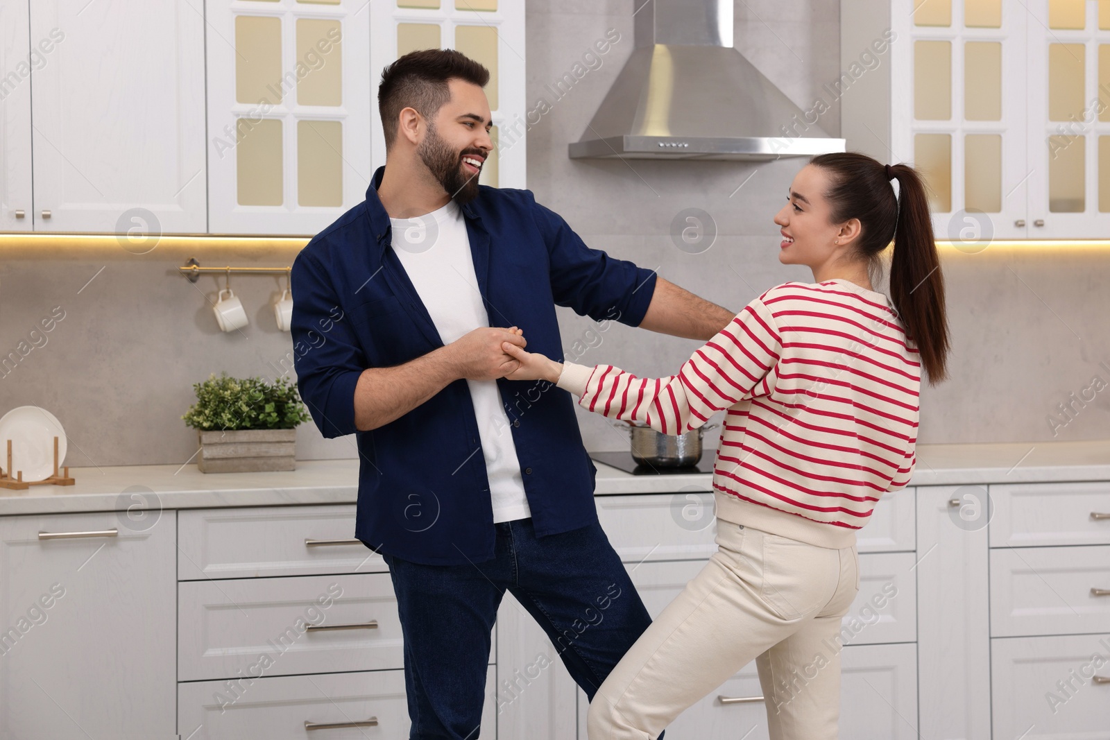 Photo of Happy lovely couple dancing together in kitchen