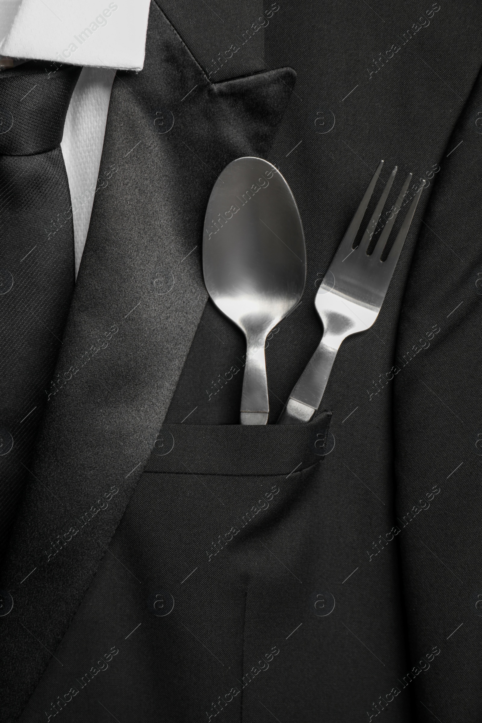 Photo of Cutlery in breast pocket of men`s jacket as background, closeup. Business lunch concept