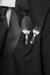 Cutlery in breast pocket of men`s jacket as background, closeup. Business lunch concept