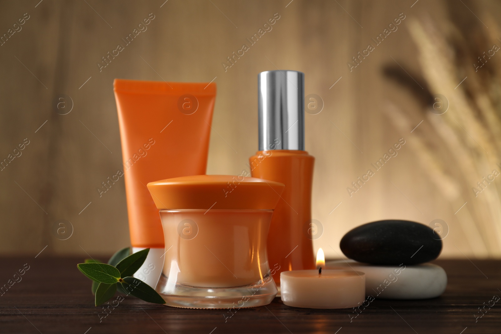 Photo of Composition with cosmetic products and spa stones on wooden table