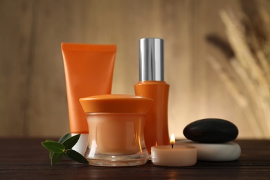 Photo of Composition with cosmetic products and spa stones on wooden table