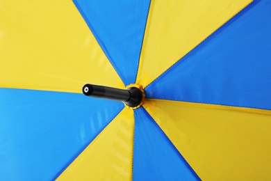 Bright yellow and blue umbrella as background, closeup