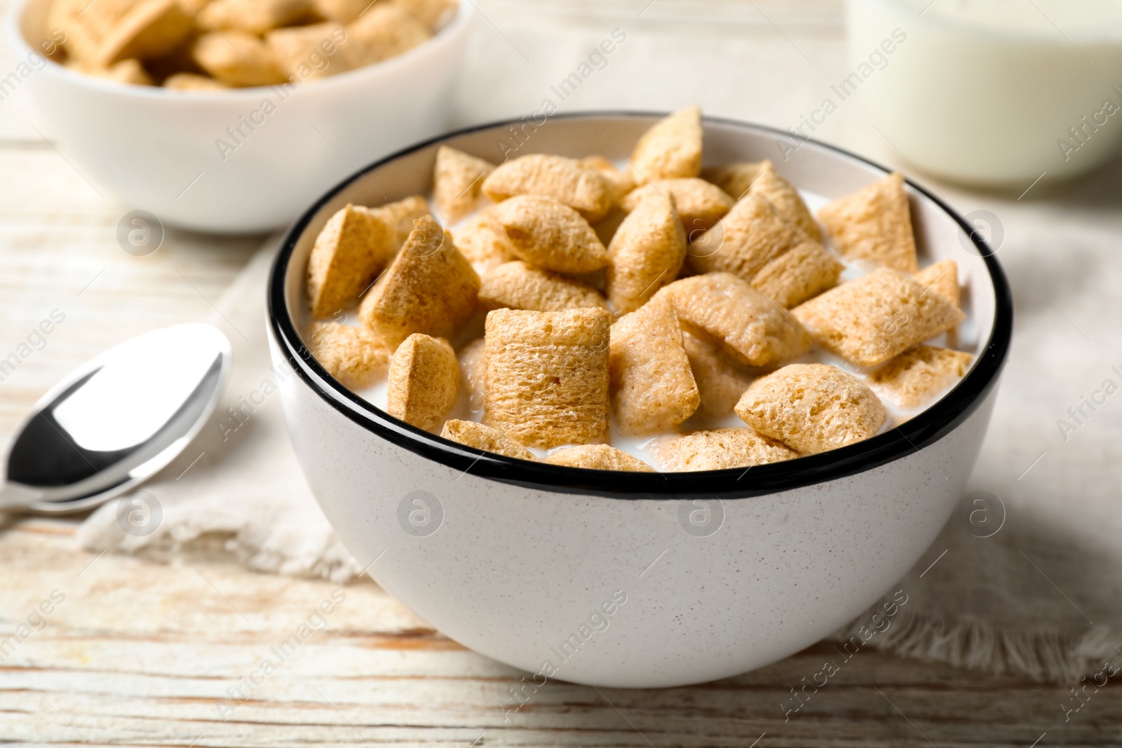 Photo of Tasty corn pads with milk served for breakfast on white wooden table, closeup