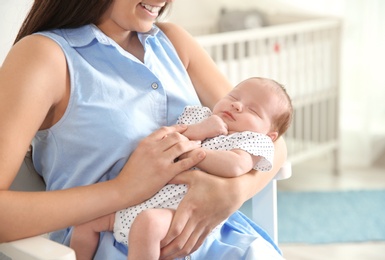 Young woman with her newborn baby at home, closeup