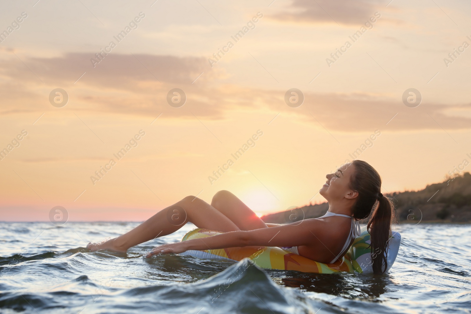 Photo of Young woman on inflatable ring in water