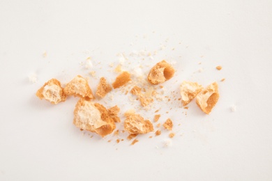 Photo of Scattered bread crumbs on white background, top view