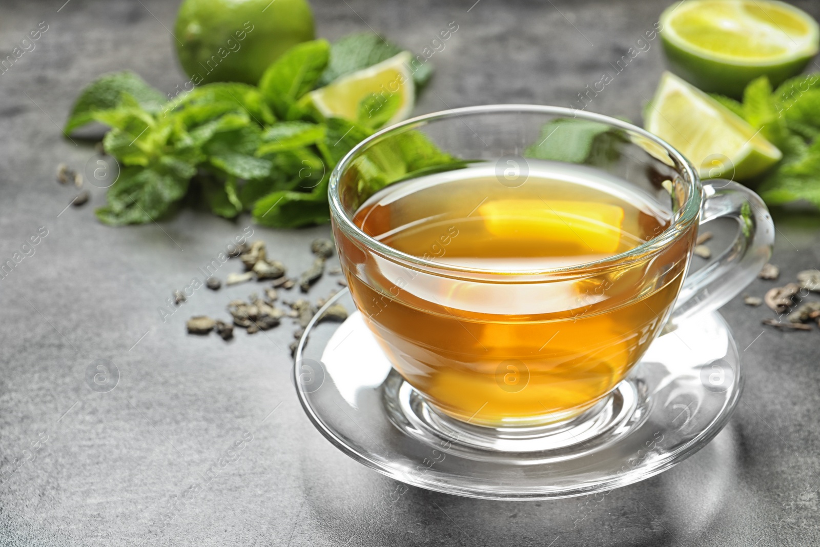 Photo of Cup with hot aromatic mint tea on table