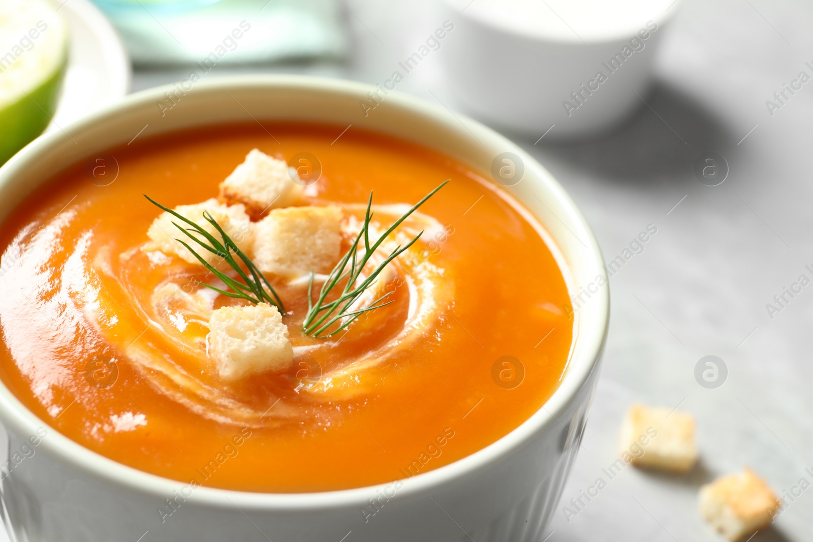 Photo of Bowl of tasty sweet potato soup on table, closeup