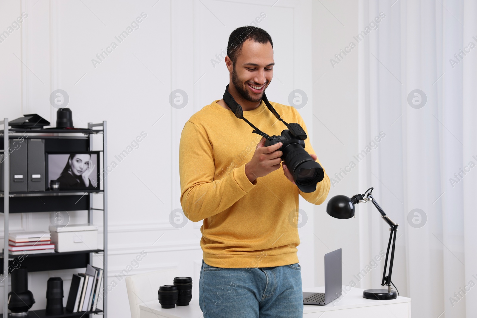 Photo of Young professional photographer with camera in modern photo studio