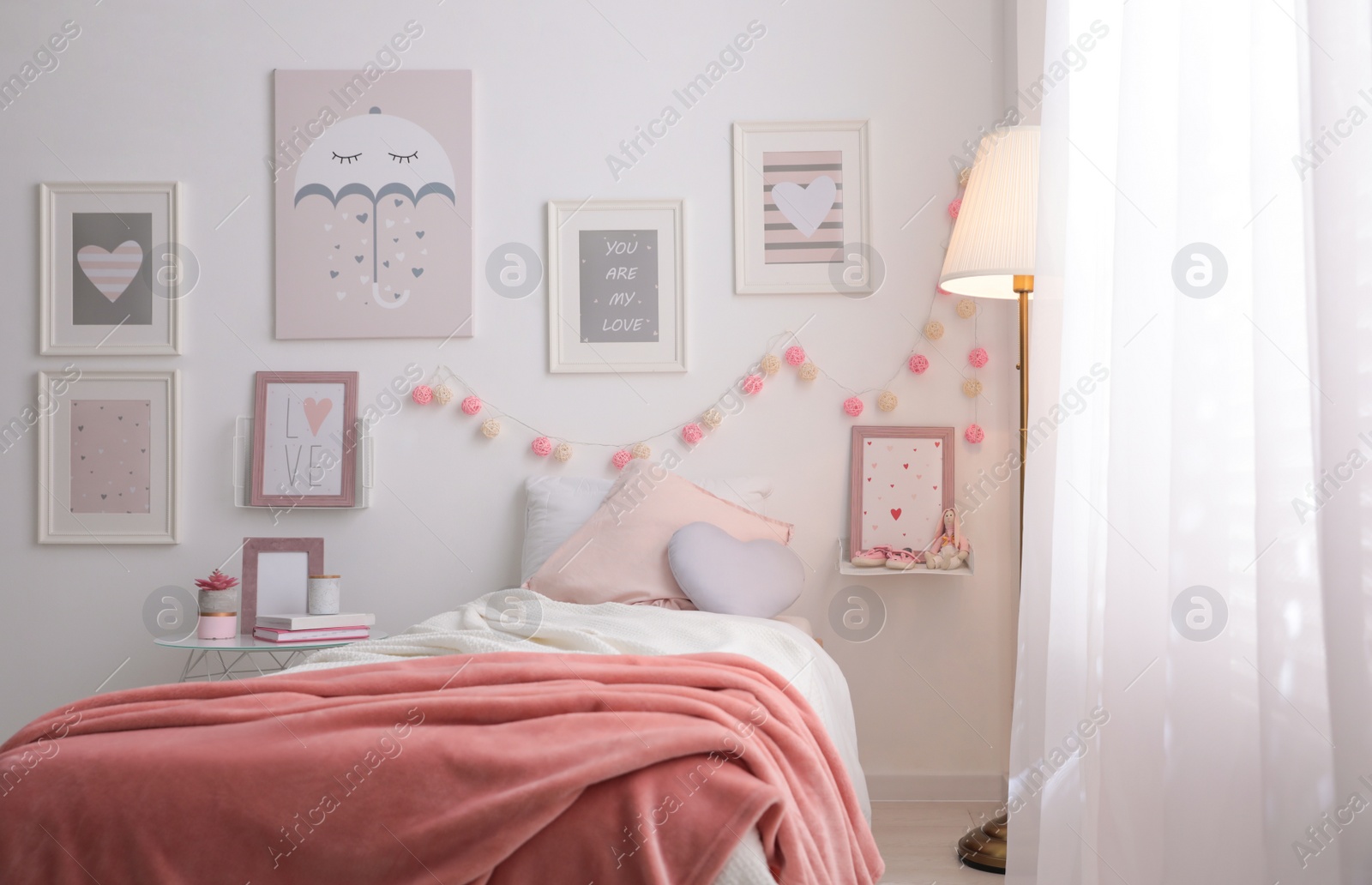 Photo of Stylish child's room interior with beautiful pictures and comfortable bed