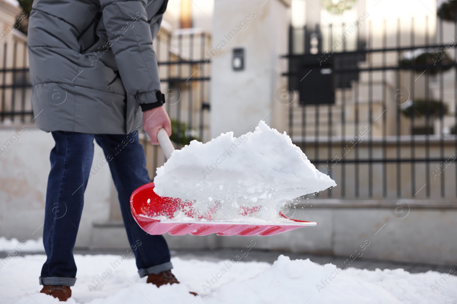 Photo of Man removing snow with shovel outdoors, closeup