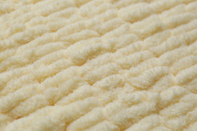 Photo of Soft beige knitted fabric as background, closeup