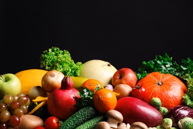Photo of Assortment of fresh organic fruits and vegetables on black background