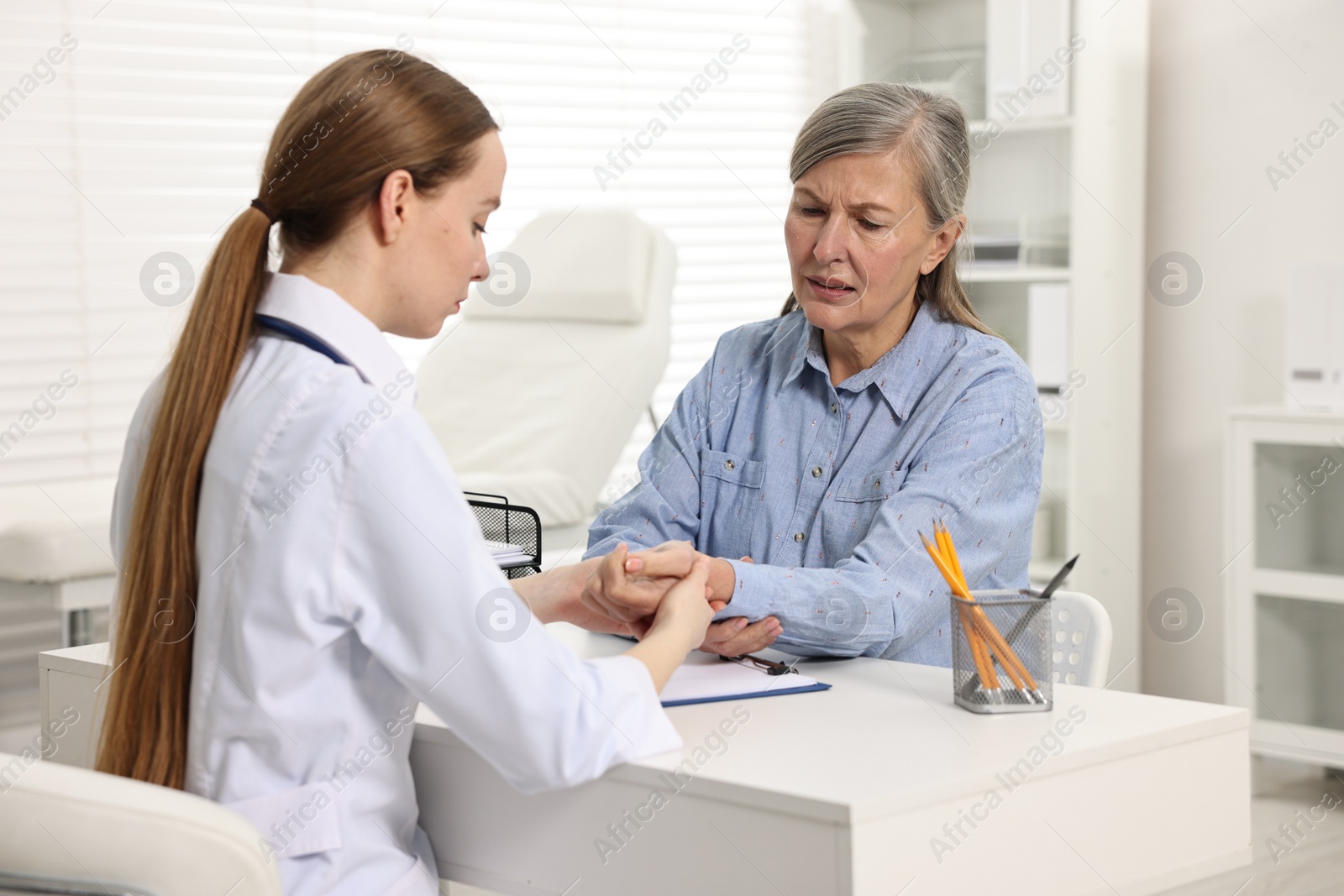 Photo of Arthritis symptoms. Doctor examining patient's wrist in hospital