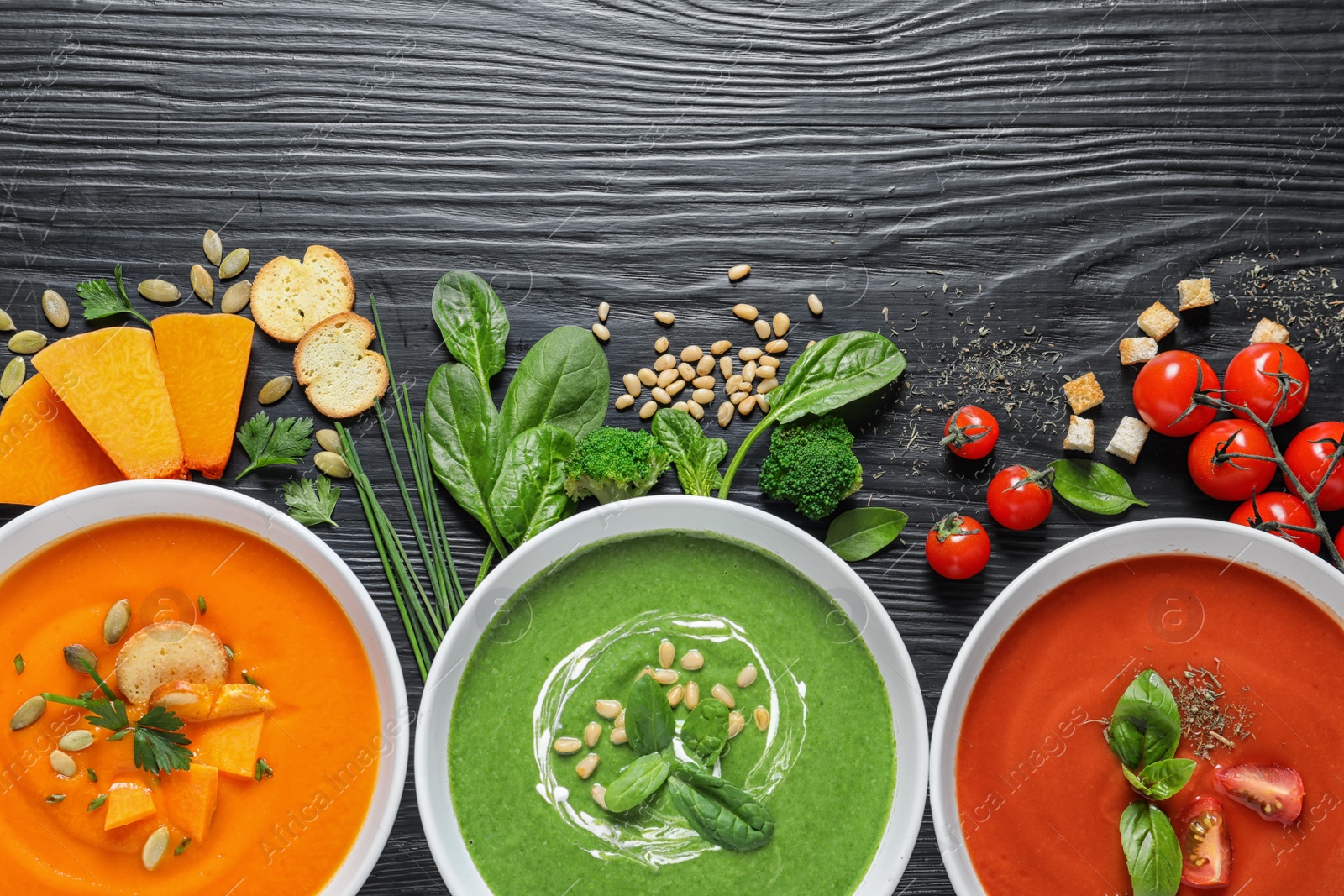 Photo of Flat lay composition with various soups and ingredients on wooden background. Healthy food