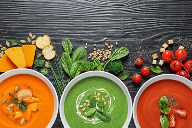 Photo of Flat lay composition with various soups and ingredients on wooden background. Healthy food