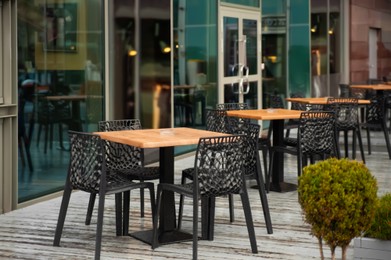 Photo of Chairs and tables on wooden terrace near cafe