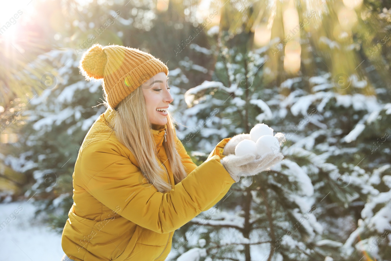 Photo of Woman holding snowballs outdoors on winter day