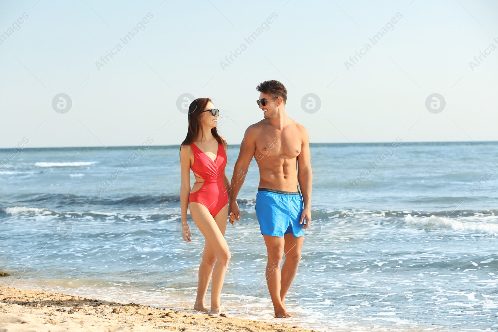 Photo of Happy young couple walking together on beach