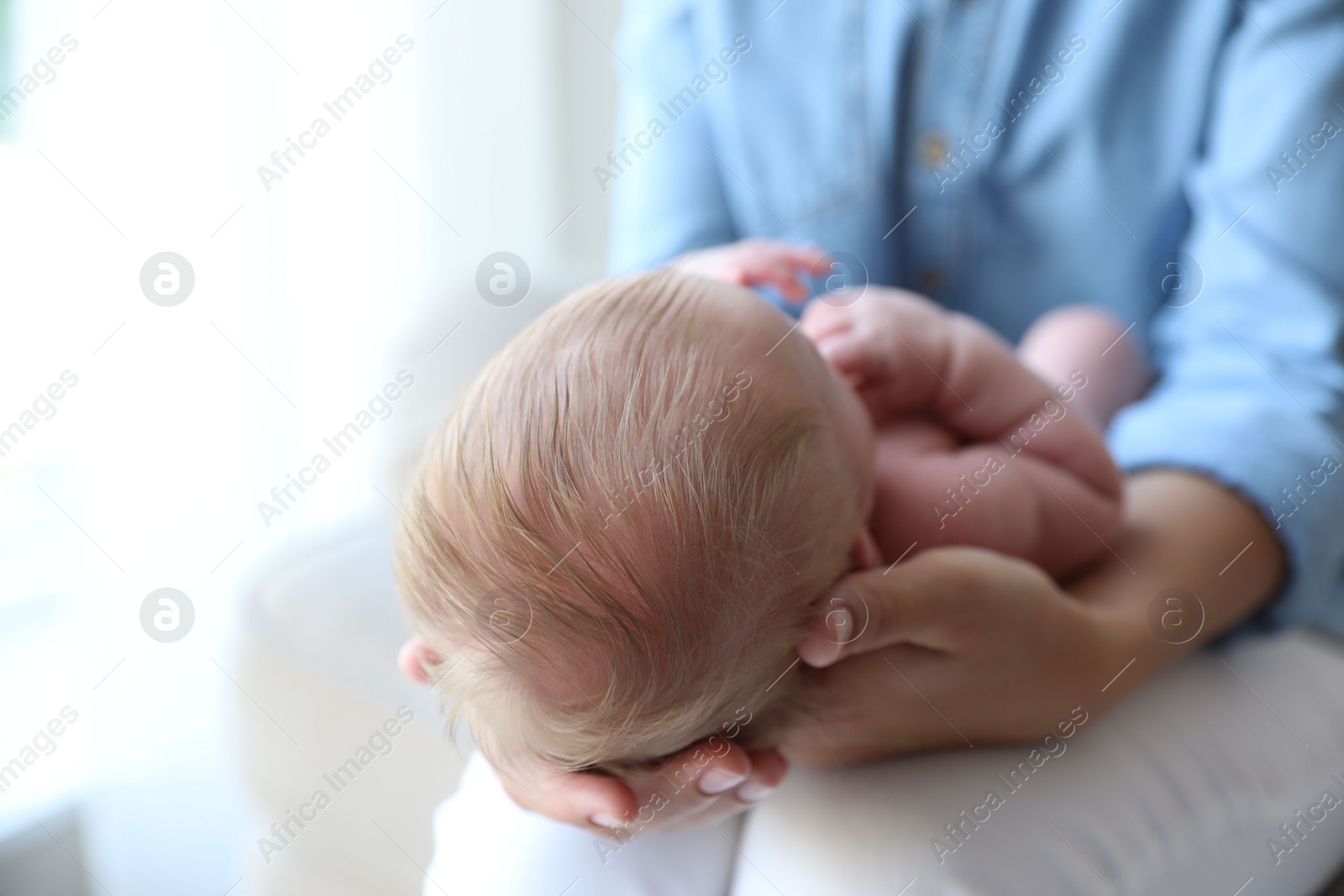 Photo of Mother holding her newborn baby at home, closeup