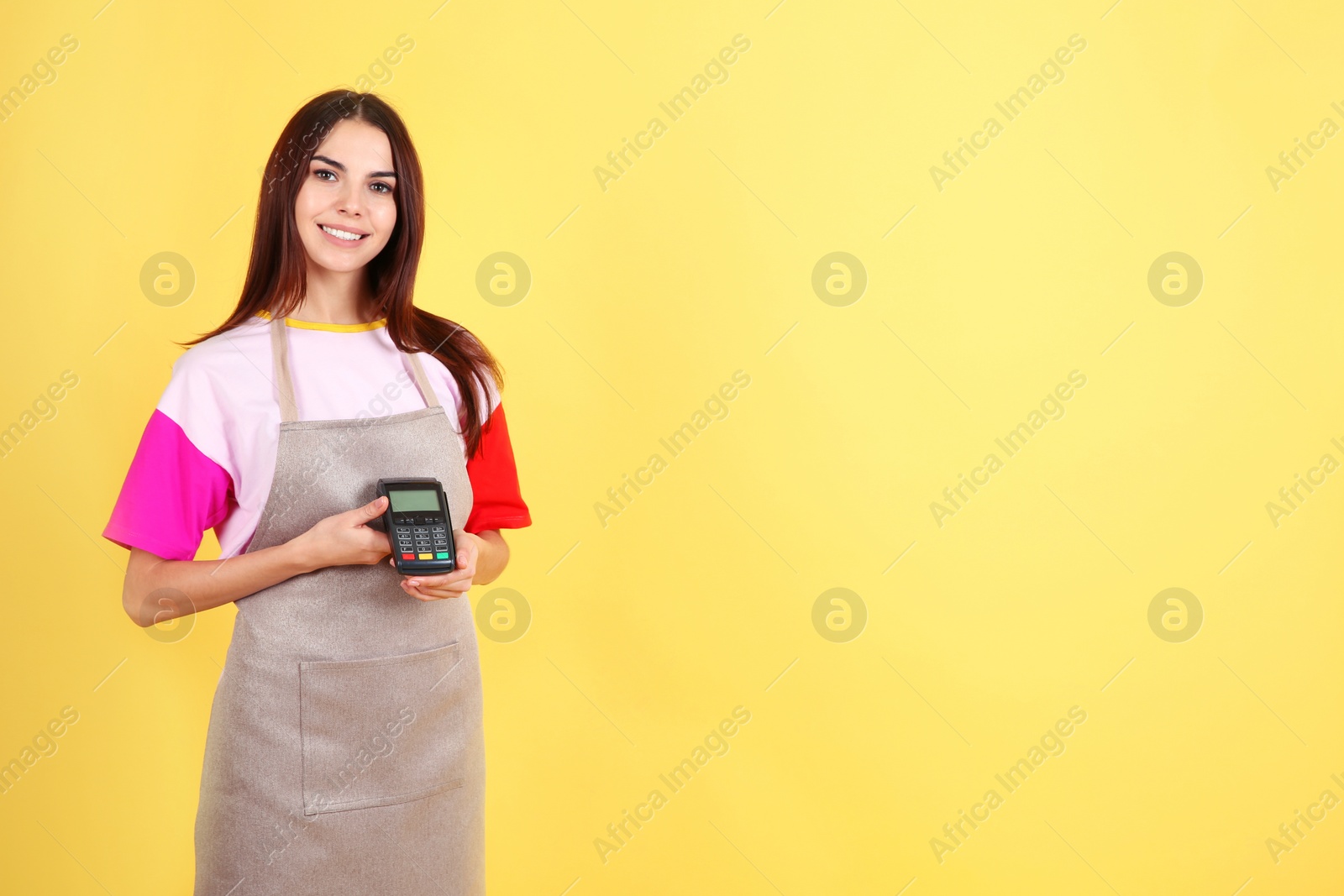 Photo of Waitress with payment terminal on color background. Space for text