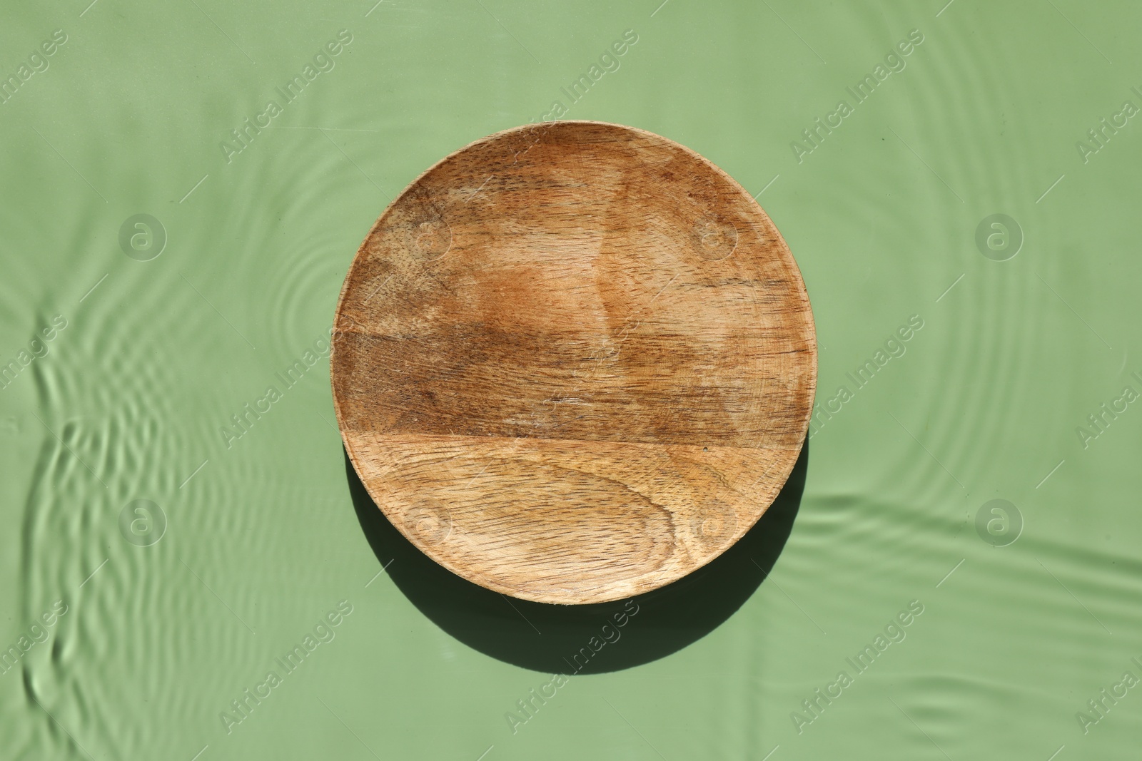 Photo of Presentation for product. Wooden podium in water on green background, top view