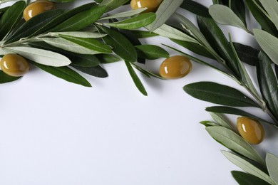 Photo of Fresh green olives and leaves on white background, flat lay. Space for text