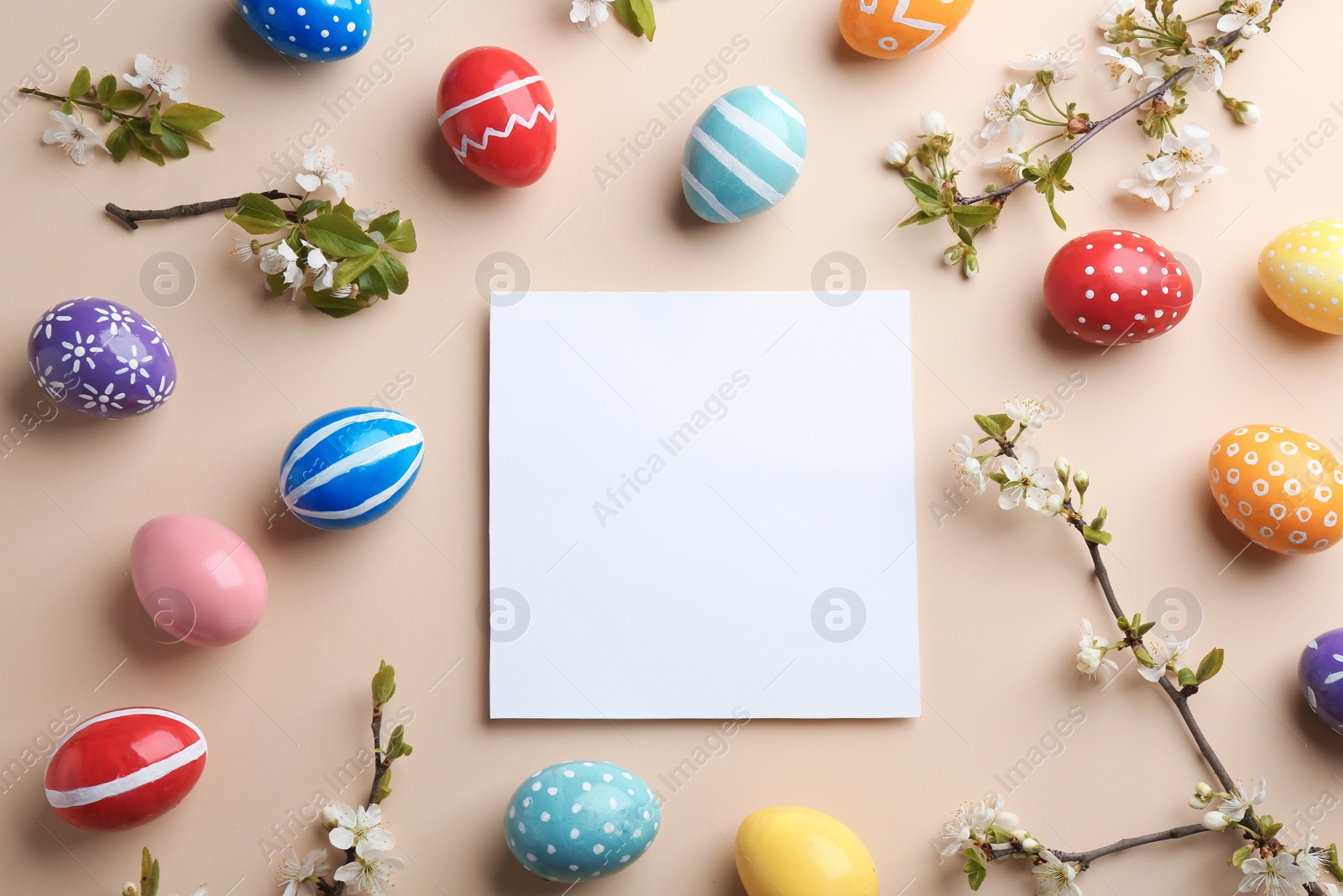 Photo of Flat lay composition with painted Easter eggs and blank card on color background, space for text