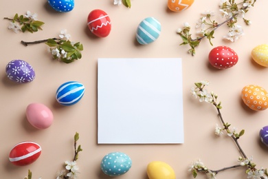 Photo of Flat lay composition with painted Easter eggs and blank card on color background, space for text