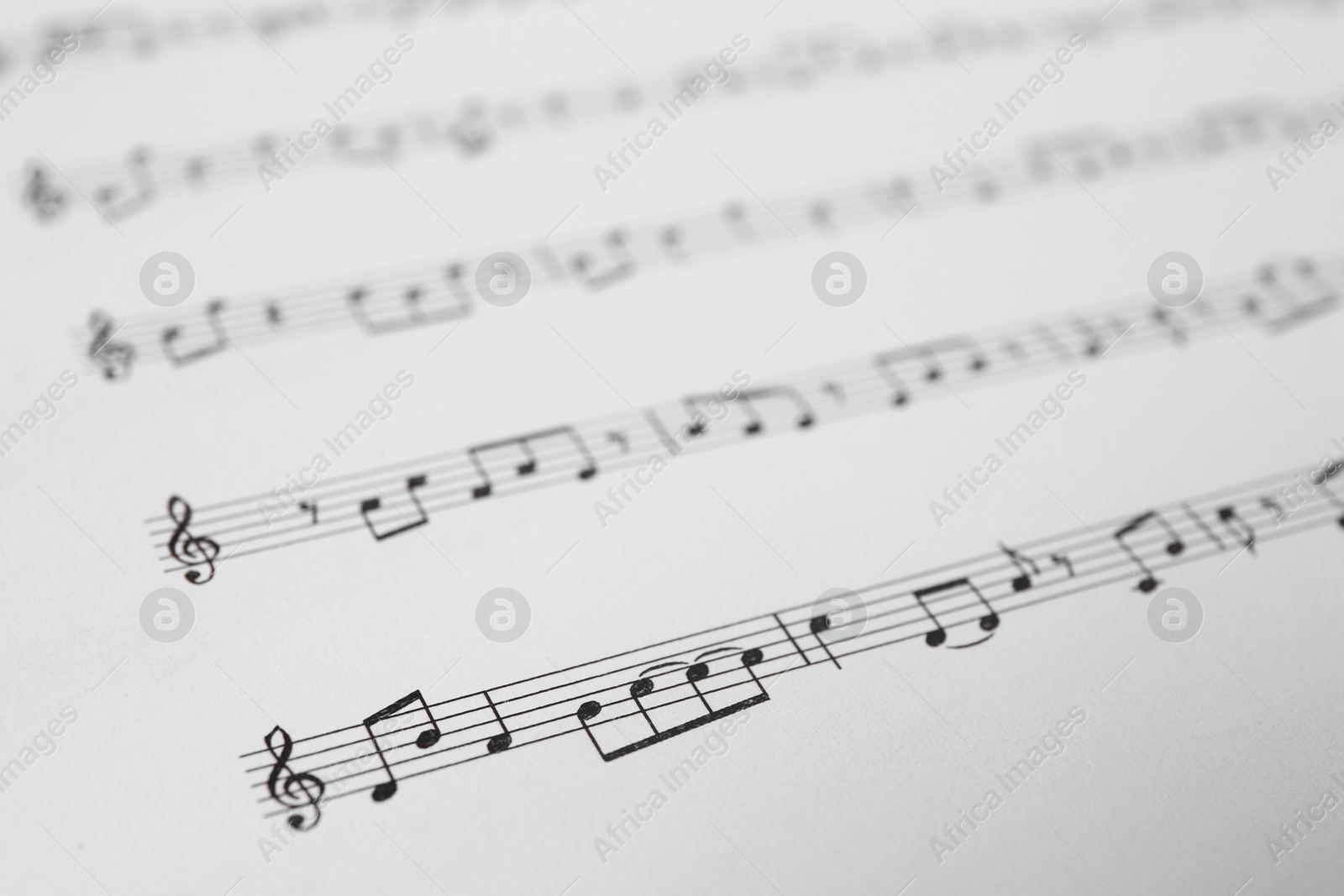 Photo of Sheet of paper with music notes as background, closeup