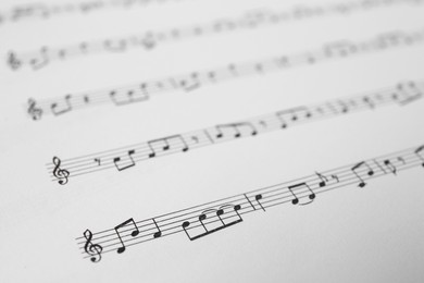 Photo of Sheet of paper with music notes as background, closeup
