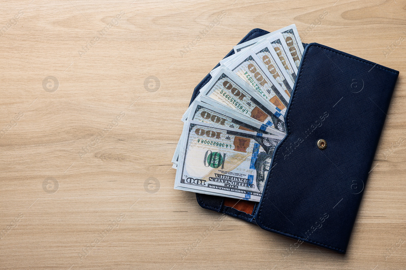 Photo of Dollar banknotes in wallet on wooden table, top view with space for text. Money exchange