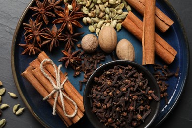 Dishware with different spices and nuts on table, top view