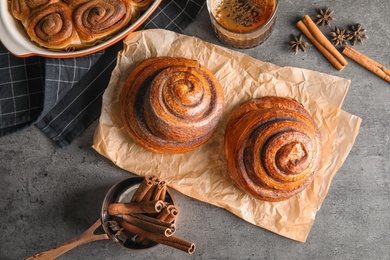 Photo of Flat lay composition with freshly baked cinnamon rolls on grey background