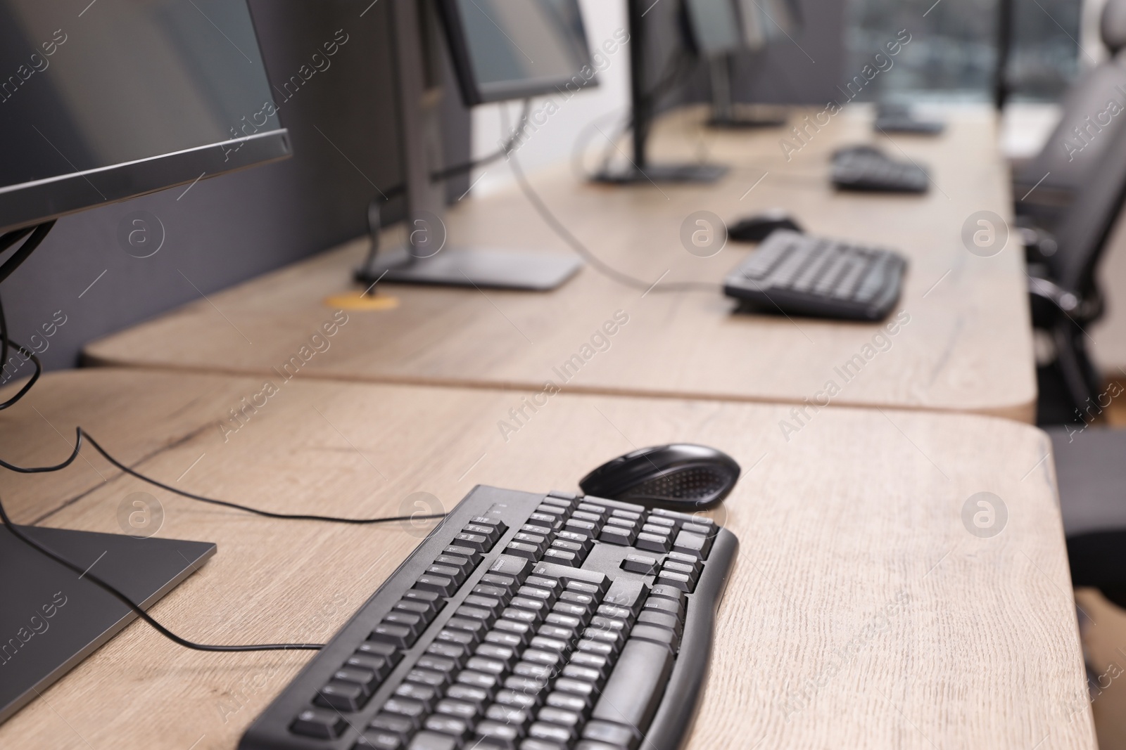 Photo of Many modern computers in open space office, closeup