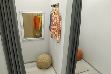 Photo of Dressing room with mirror in fashion store. Stylish design