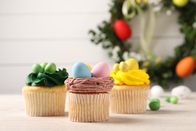 Photo of Tasty decorated Easter cupcakes on wooden table, closeup