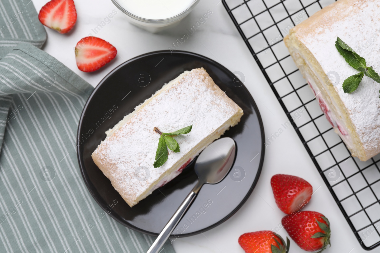 Photo of Slice of delicious sponge cake roll with strawberries and cream served on white table, flat lay