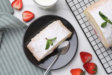 Slice of delicious sponge cake roll with strawberries and cream served on white table, flat lay