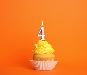 Photo of Birthday cupcake with number four candle on orange background