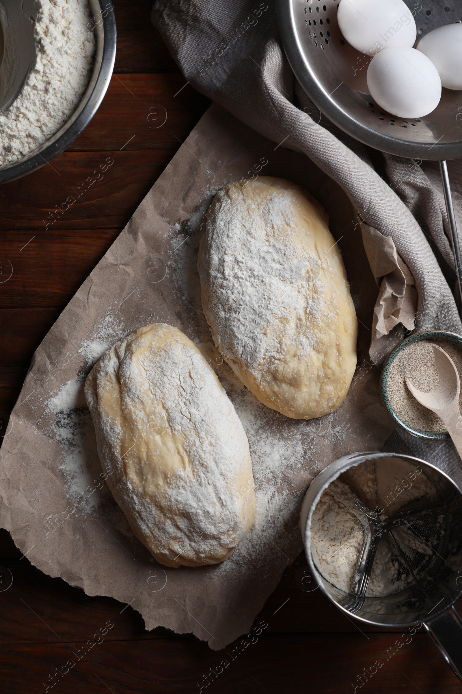 Photo of Raw dough, eggs and flour on wooden table, flat lay. Cooking ciabatta