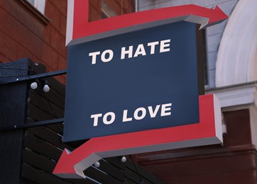Image of Sign with different directions - TO HATE or TO LOVE on building outdoors