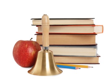 Photo of Golden school bell with wooden handle, apple and stack of books on white background