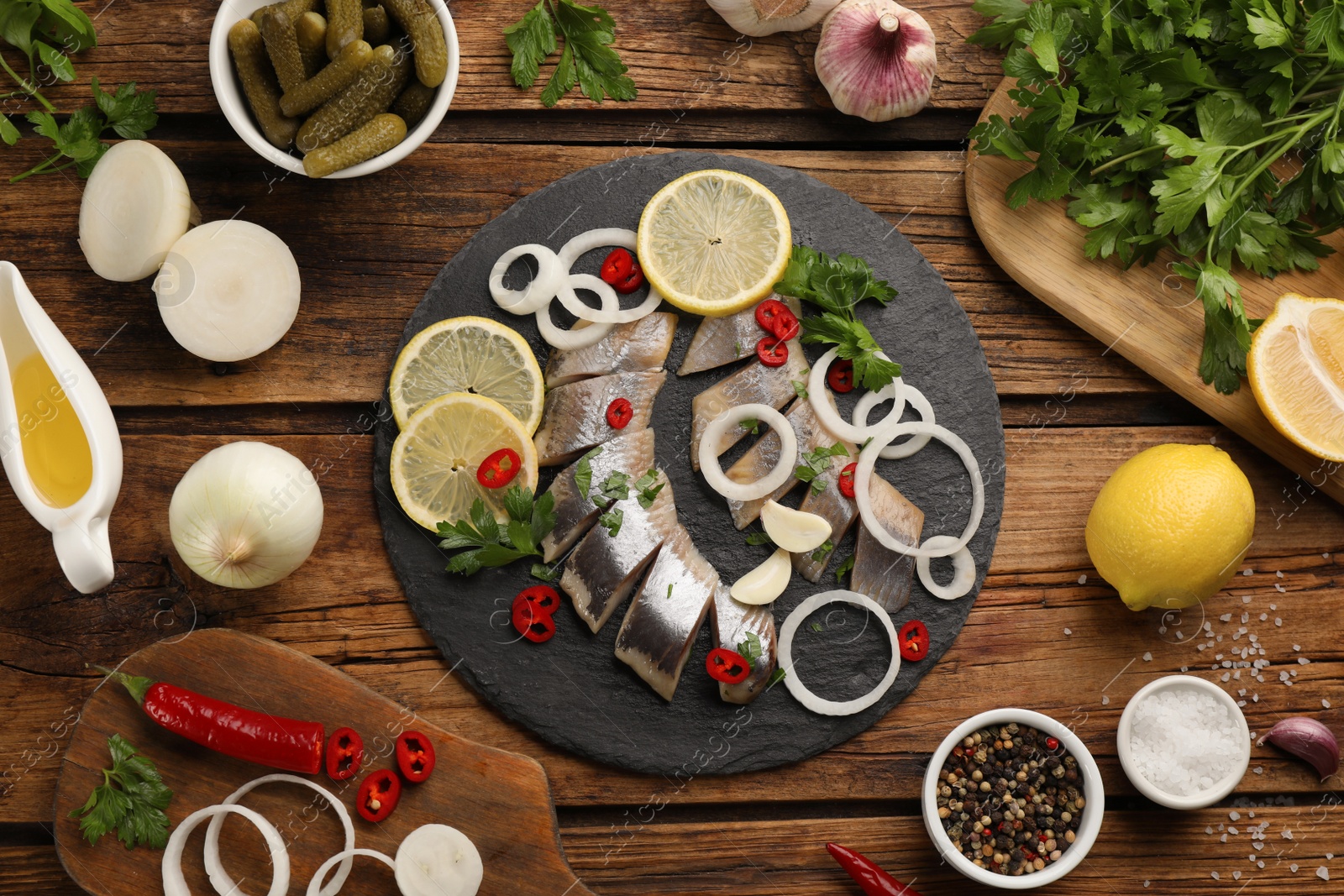 Photo of Flat lay composition with sliced salted herring fillet served on wooden table