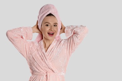 Photo of Beautiful young woman in bathrobe on light background