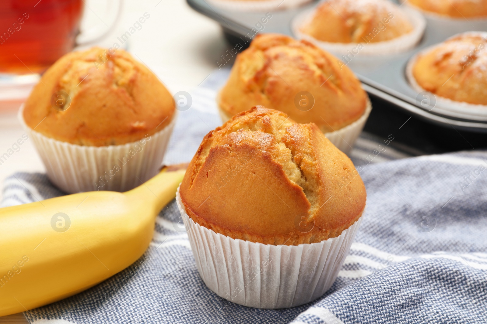 Photo of Tasty muffins and ripe banana on table, closeup