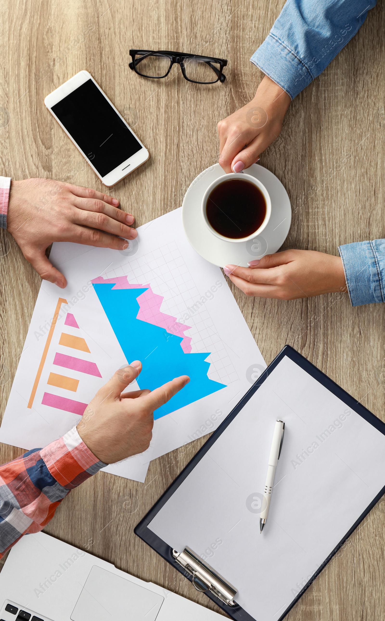 Photo of Business trainer and client working at table in office, top view