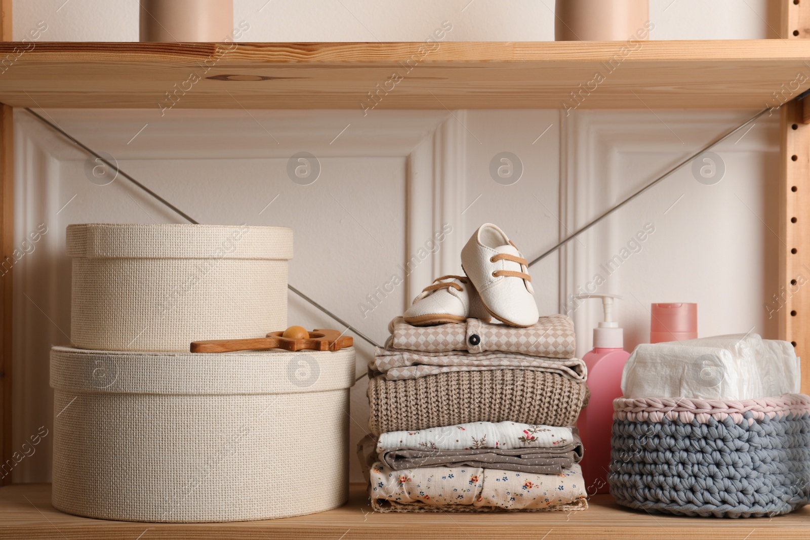 Photo of Baby clothes, shoes and accessories on wooden rack